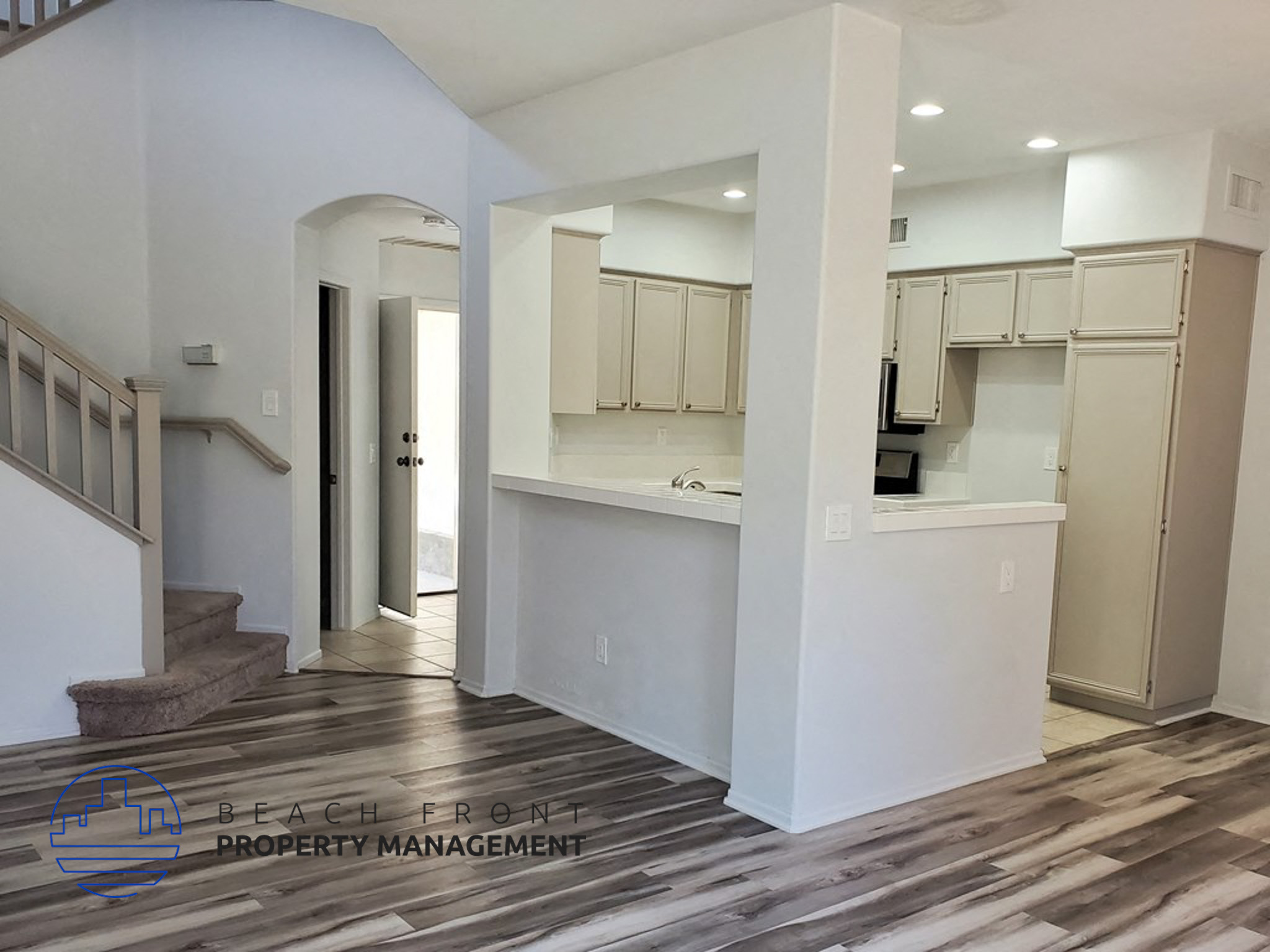 A kitchen area with a staircase leading to the upper floor.